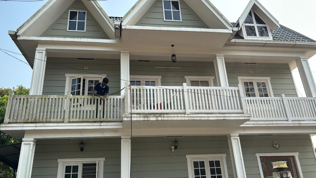 Hygienics staff cleaning the balcony and exterior of a three-storey house